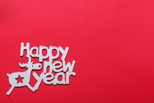beautiful branches of a Christmas tree with cones and toys on a red background with the inscription Happy New Year photo