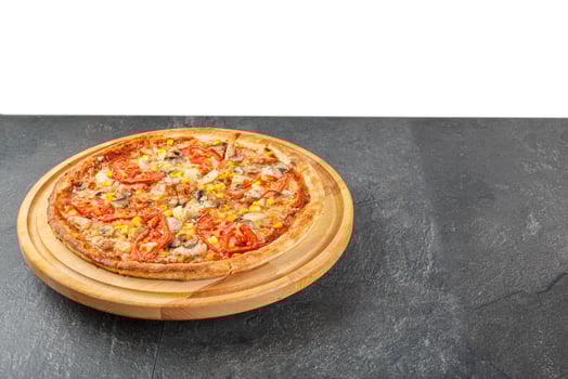 delicious pizza with chicken, mushrooms, cheese, tomatoes and corn on a concrete background photo
