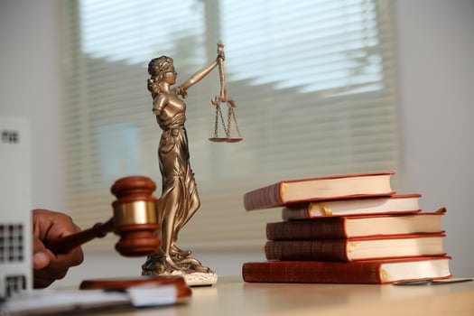 Lawyer's hand holding a gavel and books on a desk photo