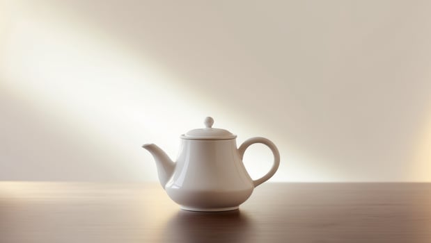 there is a white tea pot sitting on a table photo