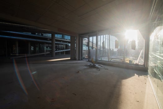 A captivating view of a modern business building under construction, showcasing its raw industrial interior with exposed steel beams and concrete walls bathed in the warm, golden hues of a sunset photo