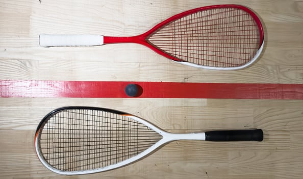 Squash rackets and ball on court floor, top view photo