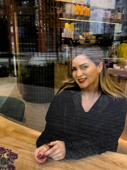 Young beautiful fashionable girl drinks coffee or tea in cafe. Model looking up. Copy, empty space for text photo