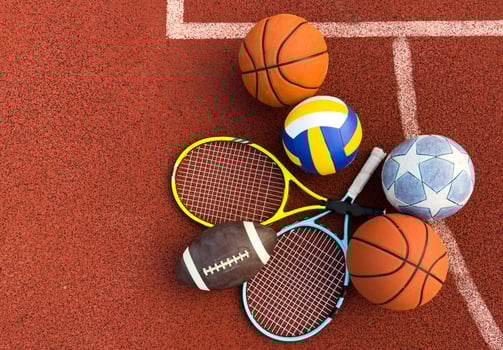 A variety of sports equipment including an american football, a soccer ball, a tennis racket, a tennis ball, and a basketball photo
