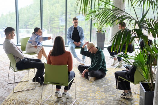 Corporate business team meeting with a manager or coach. Group of happy diverse, multiracial people sitting in a circle photo