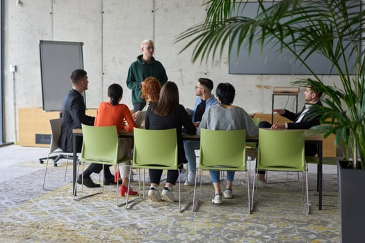 A young, diverse business team sitting together in a modern office, exchanging ideas and business plans, fostering collaboration and innovation for future success. photo