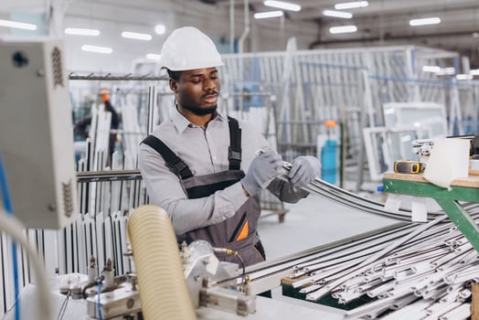 Factory worker assembling aluminum window frames in production line photo