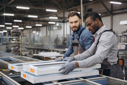 Factory workers handling aluminum and pvc window frames on production line photo