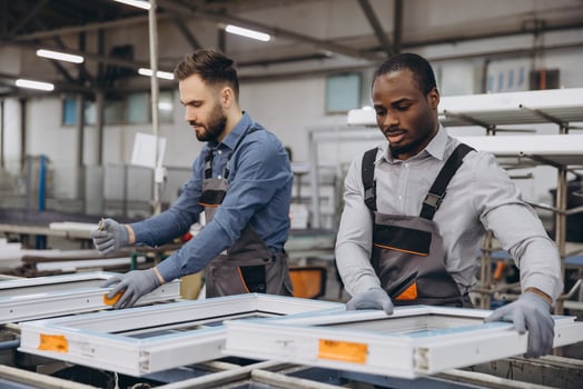 Factory workers assembling PVC window frames in production line photo