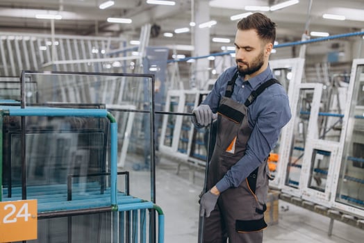 Factory worker handling glass for pvc windows and doors production photo