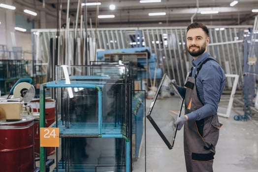 Factory worker holding glass pane for pvc windows and doors production photo