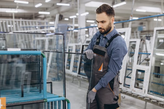 Factory worker handling glass for pvc windows and doors production photo