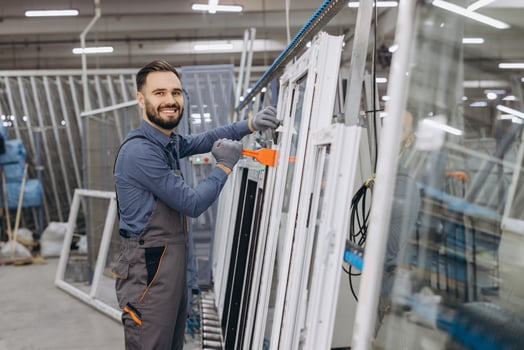 Factory worker assembling aluminum and PVC window frames in production line photo
