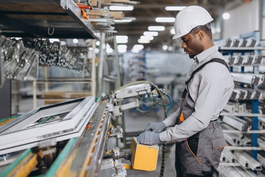 Factory worker operating machinery producing PVC windows and doors photo