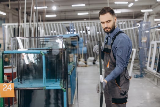 Factory worker carrying glass for pvc windows and doors production photo