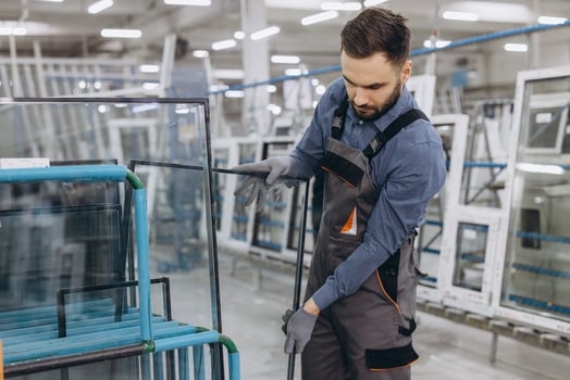 Factory worker checking glass pane for pvc windows production photo