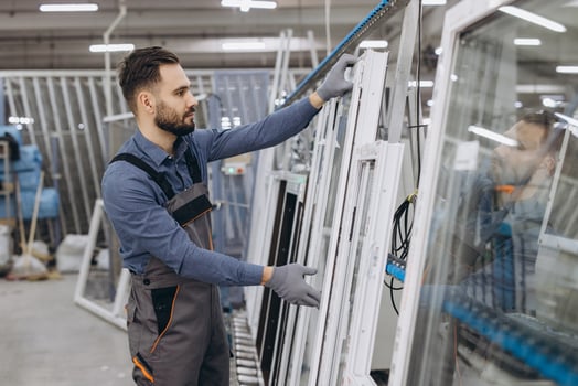 Factory worker checking aluminum and PVC windows and doors in production line photo