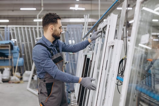 Factory worker checking aluminum and pvc windows and doors in production line photo