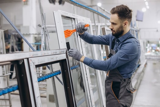 Factory worker assembling aluminum and pvc window frame photo