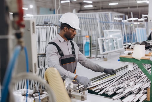 Factory worker preparing PVC window and door frames for assembly photo
