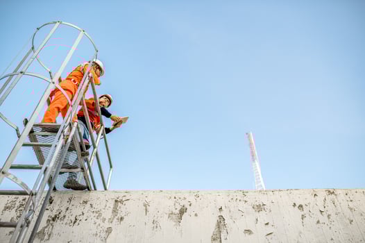 Two maintenance technicians and solar panel installers are planning to install solar cells on the roof of a building. photo