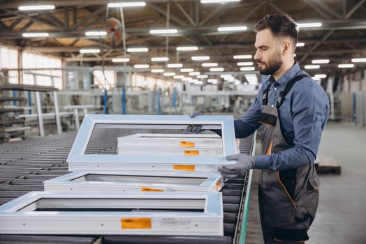 Factory worker checking aluminum and pvc window frames on production line photo