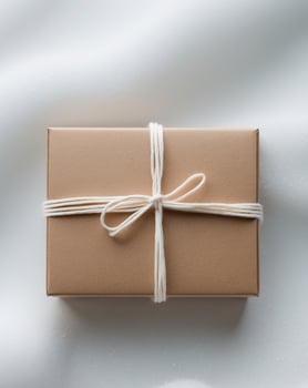 A brown gift box tied with twine on a white background photo