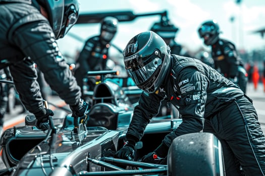 A group of men in black suits working on a race car photo