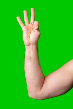 A close-up of a hand displaying a three-finger gesture against a bright green background photo