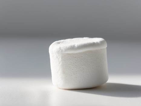 A marshmallow on a white surface photo