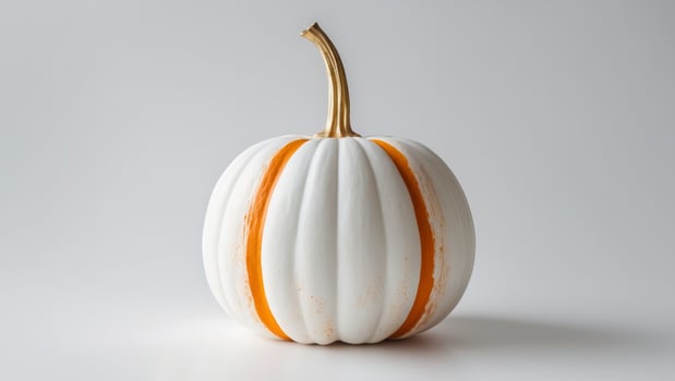 A white pumpkin with orange stripes on it photo