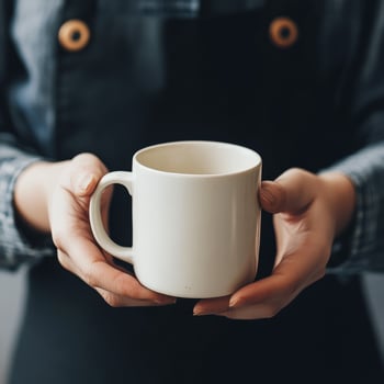 A person holding a white coffee cup photo