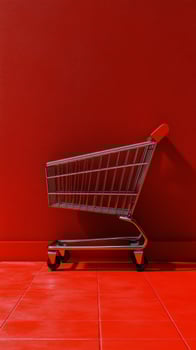 Empty shopping cart against a vibrant red background in a minimalistic setting photo