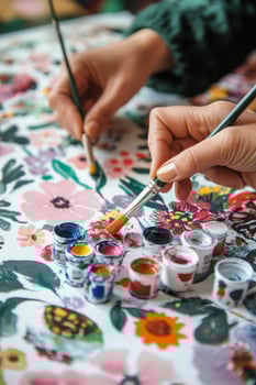 Hand painting on a floral canvas with vibrant colors and watercolor paints indoors photo
