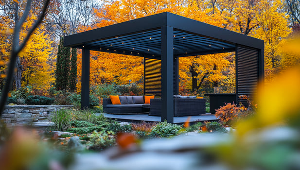 A black gazebo with orange cushions and a black table. The gazebo is surrounded by trees and plants photo