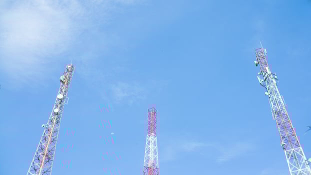 telecommunication tower against blue sky with moon in afternoon photo