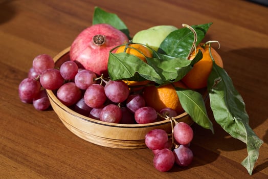 A Colorful Assortment of Fresh and Juicy Fruits beautifully arranged in a Rustic Wooden Bowl photo