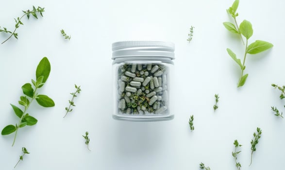 A jar of pills is on a white background with green leaves photo