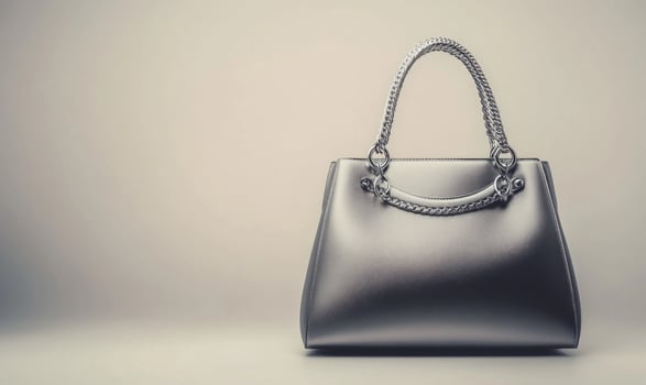 A silver purse with a gold chain strap photo