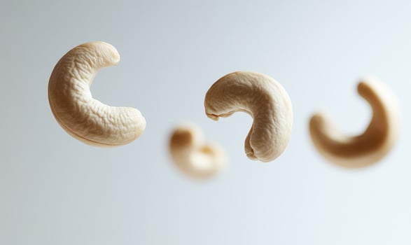 Three cashews are flying in the air closeup view photo