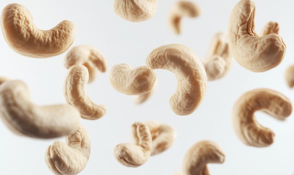 A bunch of cashews are flying through the air closeup photo
