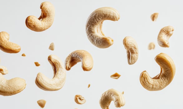 A bunch of cashews are flying through the air closeup view photo
