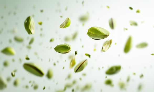 A bunch of green nuts are flying through the air photo