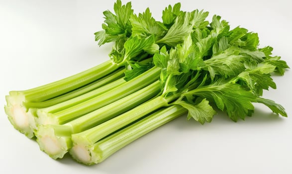 A bunch of celery stalks are sitting on a white table photo