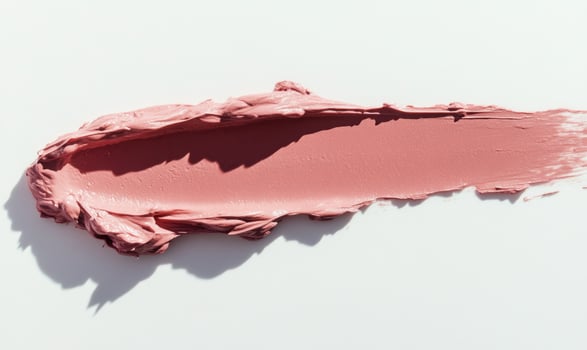 A pink lip gloss is shown on a white background, hard light photo