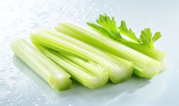 A bunch of celery sticks are on a white surface photo