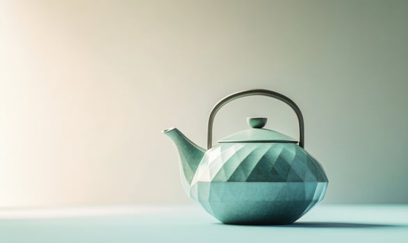 A blue teapot with a handle sits on a table photo