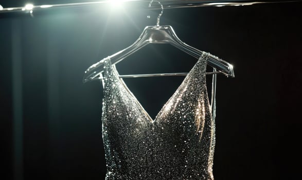 a silver dress on a hanger in a dark room photo