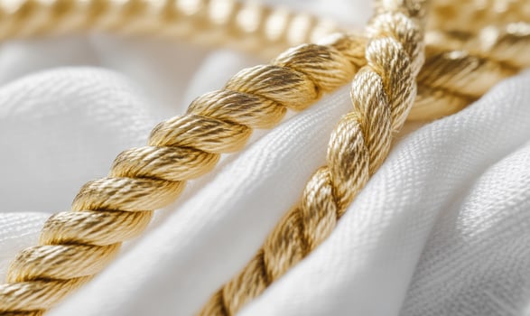 A gold rope is wrapped around a white cloth photo