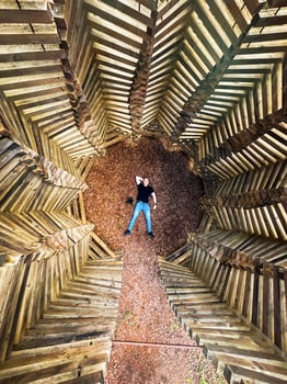 Aerial View of Person in Geometric Wooden Structure with Pebble Ground photo